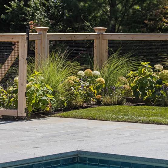 Cedar-framed wire fence with gate beside a pool