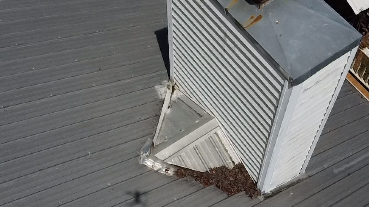 Drone photo of a chimney with failed flashing and debris packed against it