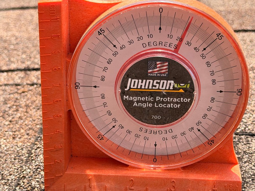 Pitch gauge on a shingle roof reading the slope